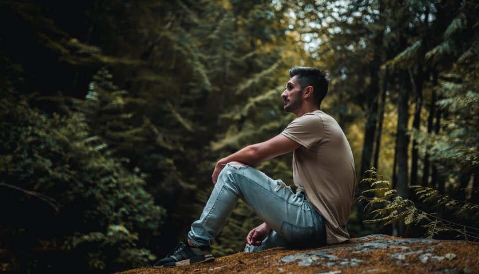 Muž sedí v lese
